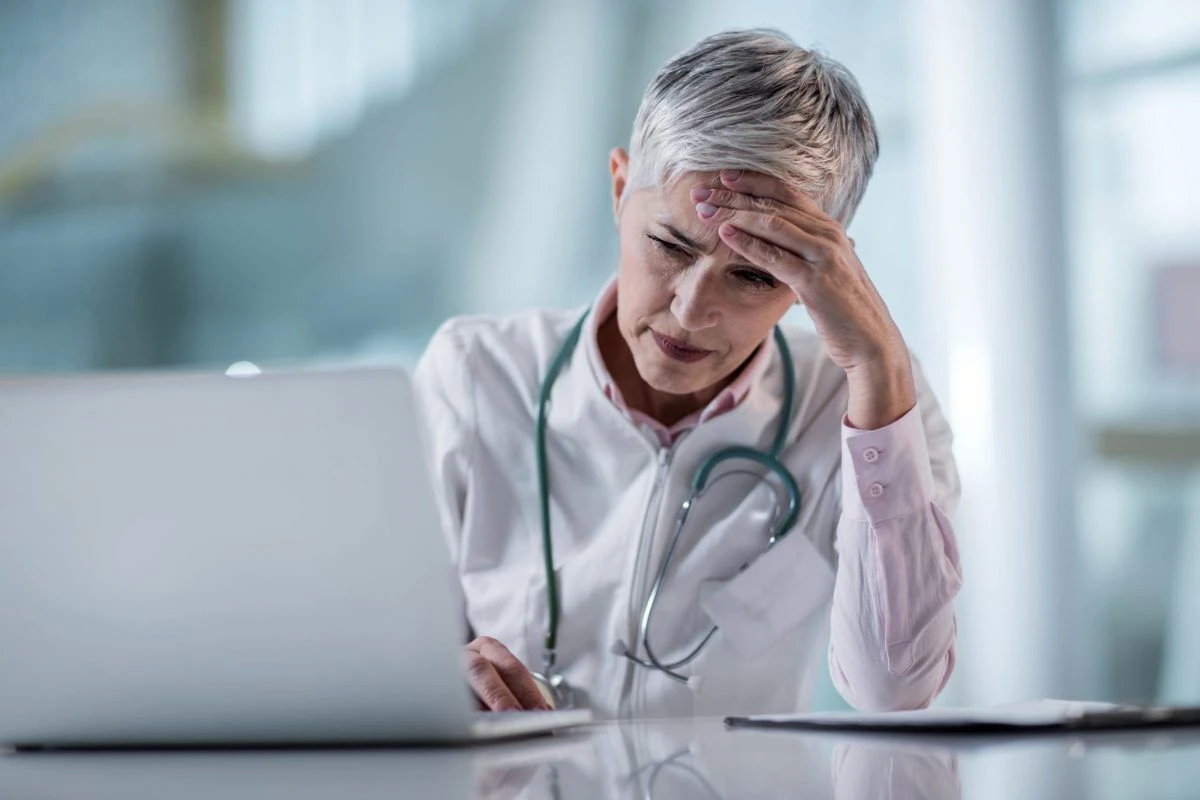 Healthcare worker stressed while writing a Plan of Correction